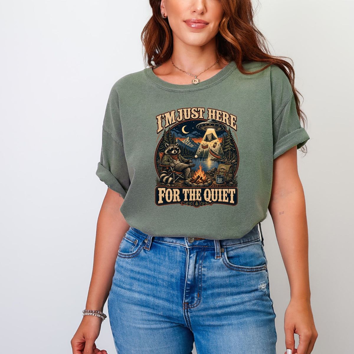 Green t-shirt with raccoon and UFO graphic and text I'M JUST HERE FOR THE QUIET.