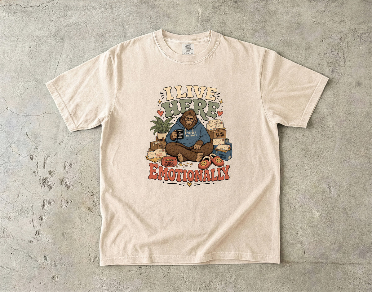 Bigfoot sits with a mug and boxes, text reads "I live here emotionally".