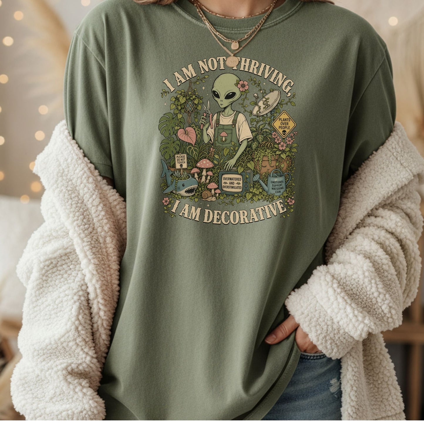 Alien in overalls tending plants with text "I AM NOT THRIVING, I AM DECORATIVE".