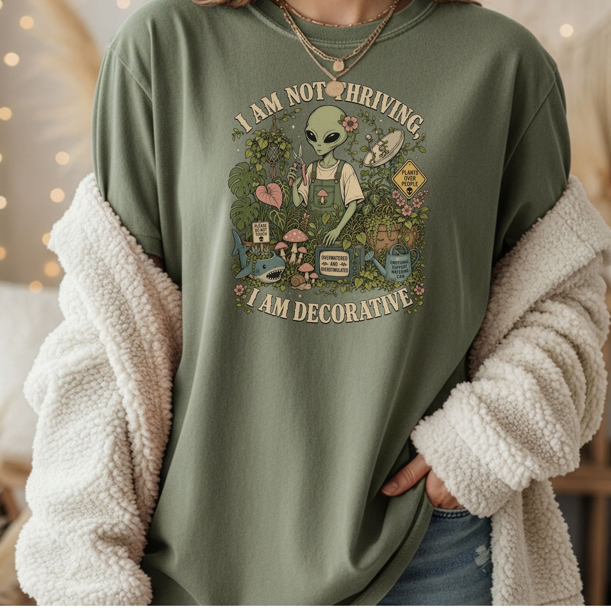 Alien in overalls tending plants with text "I AM NOT THRIVING, I AM DECORATIVE".