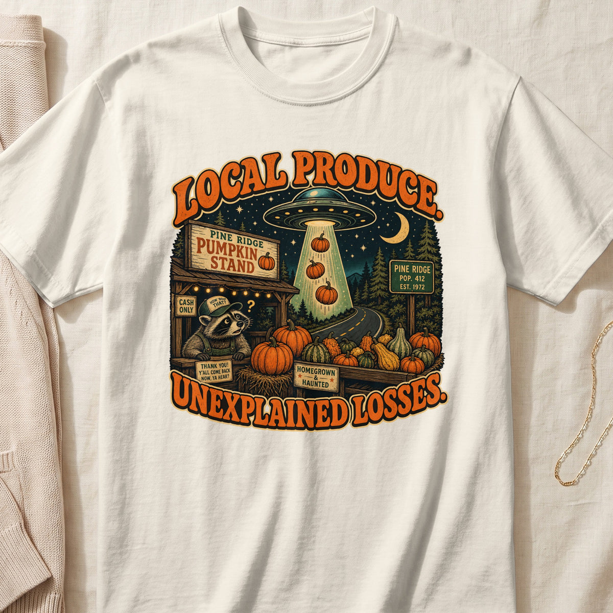 T-shirt with graphic: Local Produce Unexplained Losses, alien abduction at pumpkin stand.