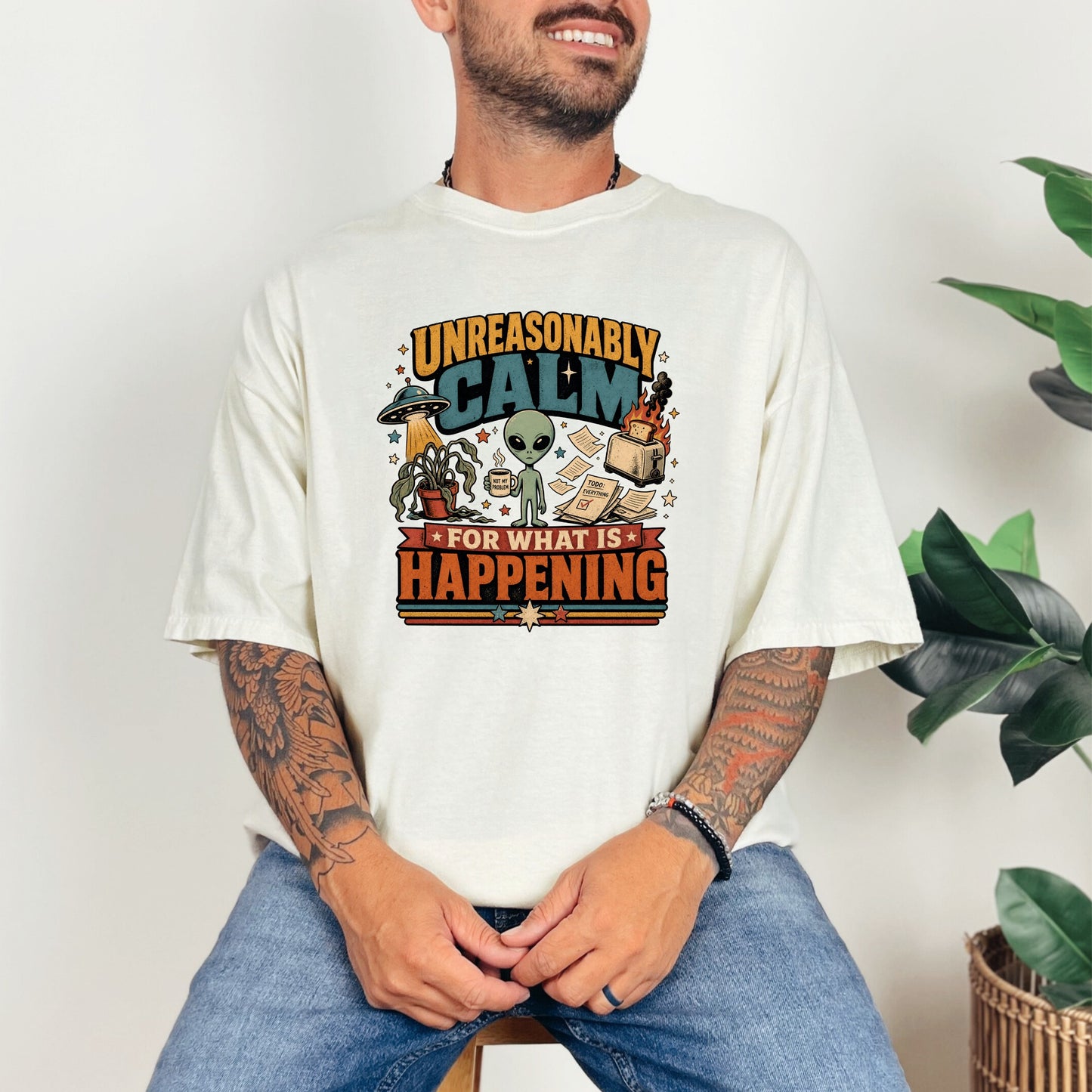 Graphic tee with an alien, UFO, and burning toast saying "Unreasonably Calm For What is Happening".