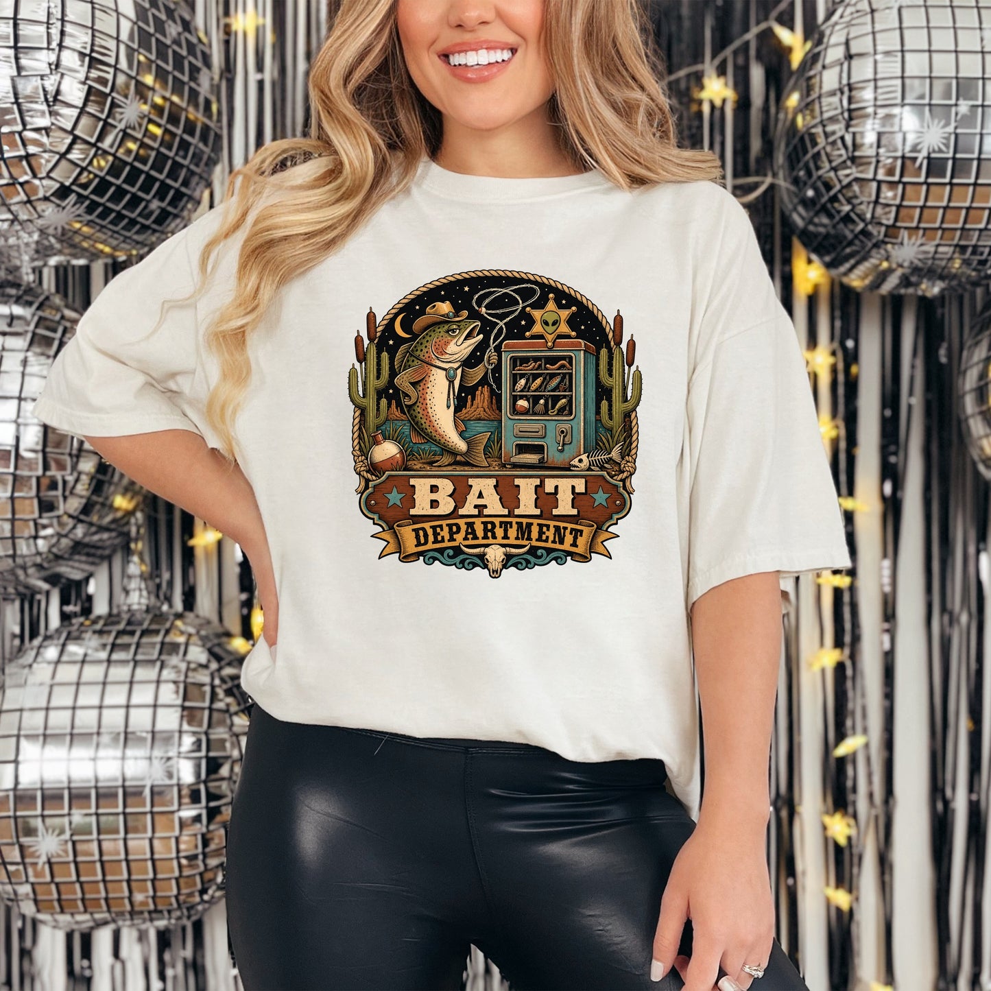 A woman wearing a white t-shirt featuring a vintage western graphic that reads Bait Department.