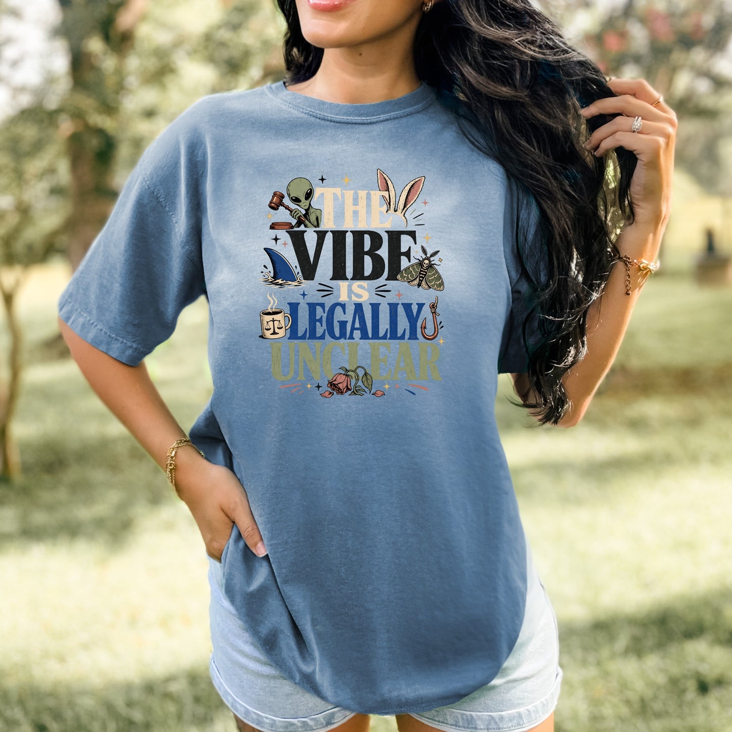 Blue t-shirt with text "THE VIBE IS LEGALLY UNCLEAR" and assorted graphics.