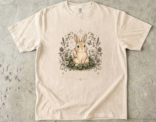 Light beige t-shirt with a rabbit giving the middle finger surrounded by flowers and text.