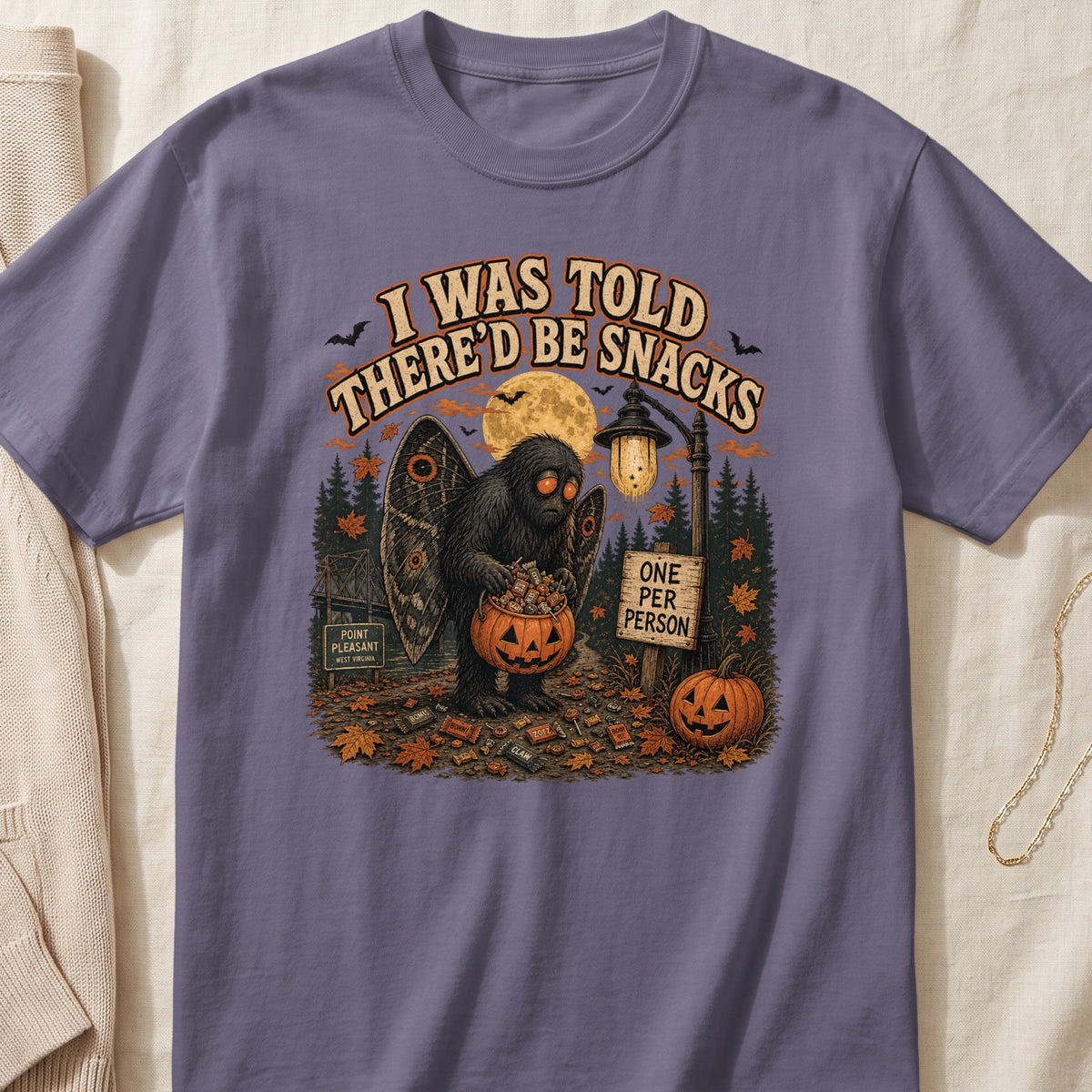 Mothman holding pumpkin bucket with candy; text reads "I WAS TOLD THERE'D BE SNACKS."