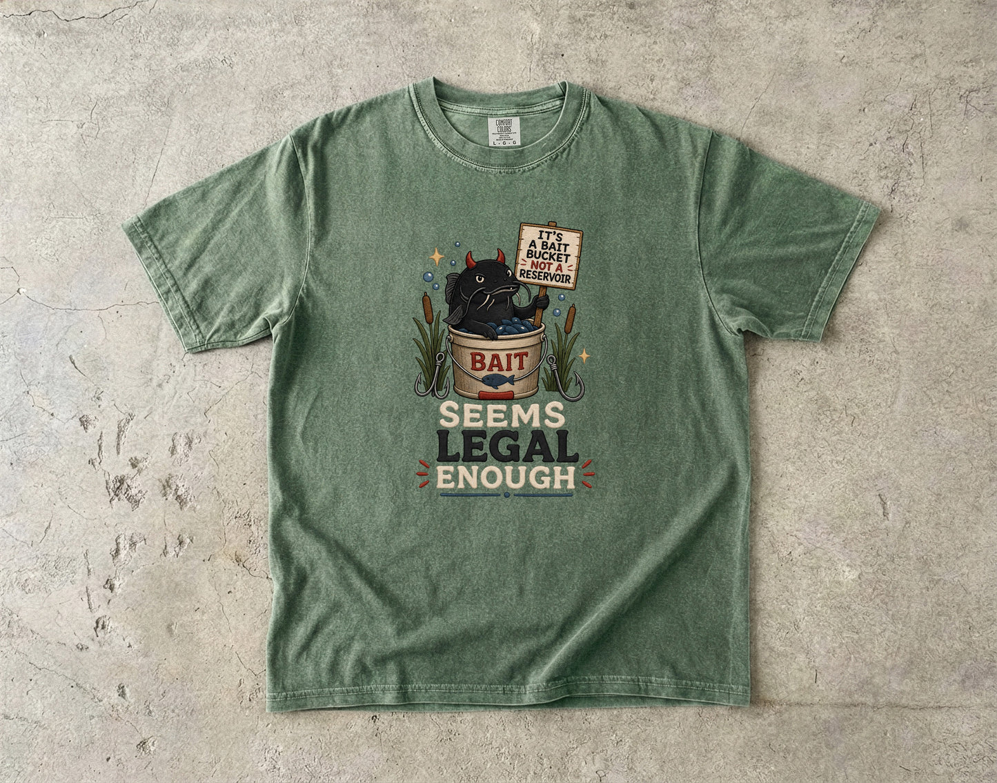 Green t-shirt with cartoon devil catfish in a bait bucket: "It's a bait bucket, not a reservoir. Seems legal enough."