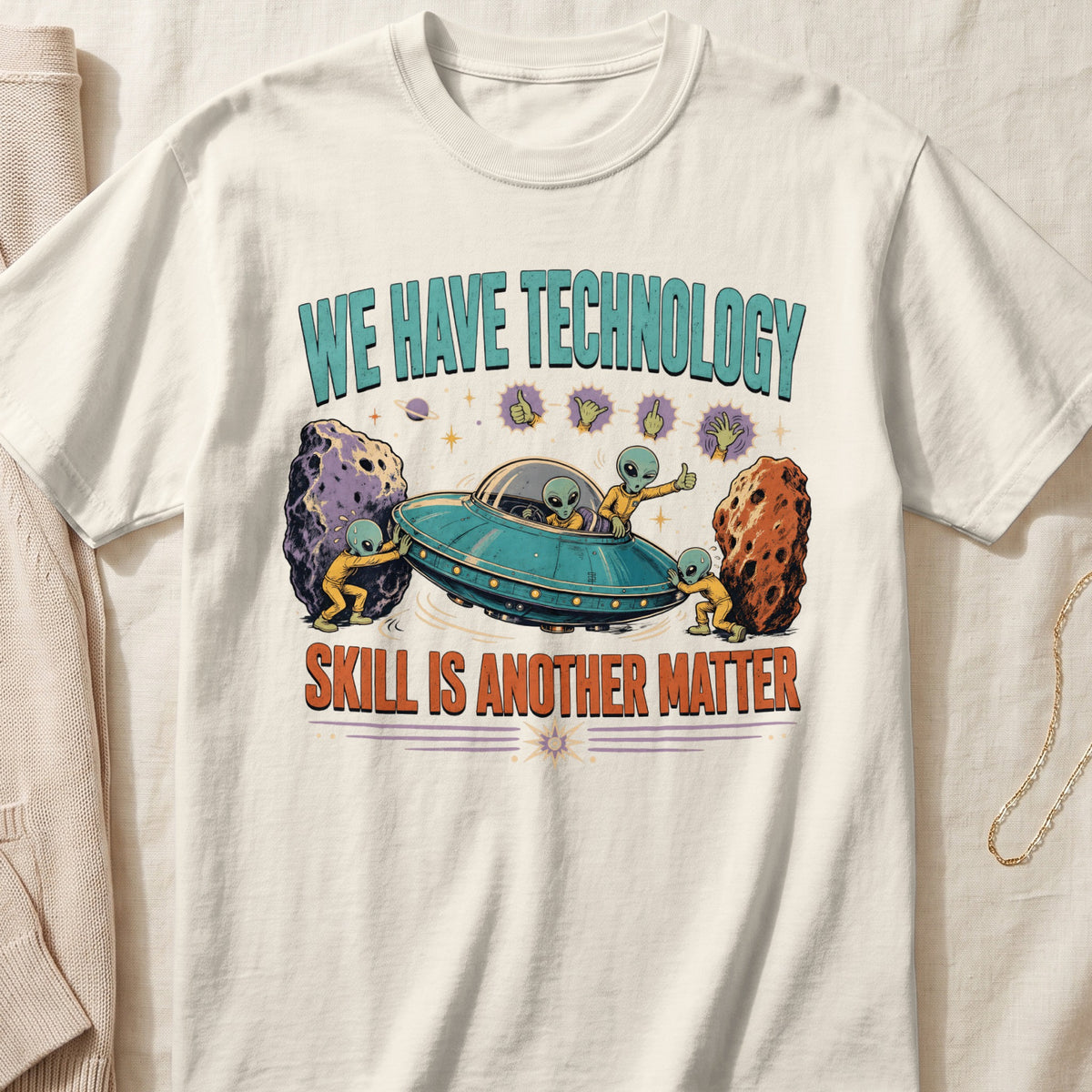 T-shirt with aliens pushing meteors and a UFO, text reads "We Have Technology Skill Is Another Matter".