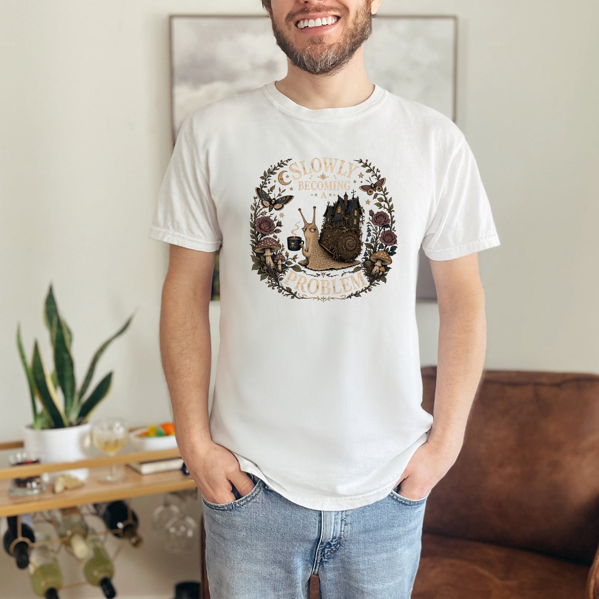 White t-shirt with a circular graphic featuring a snail and the text "Slowly Becoming a Problem".