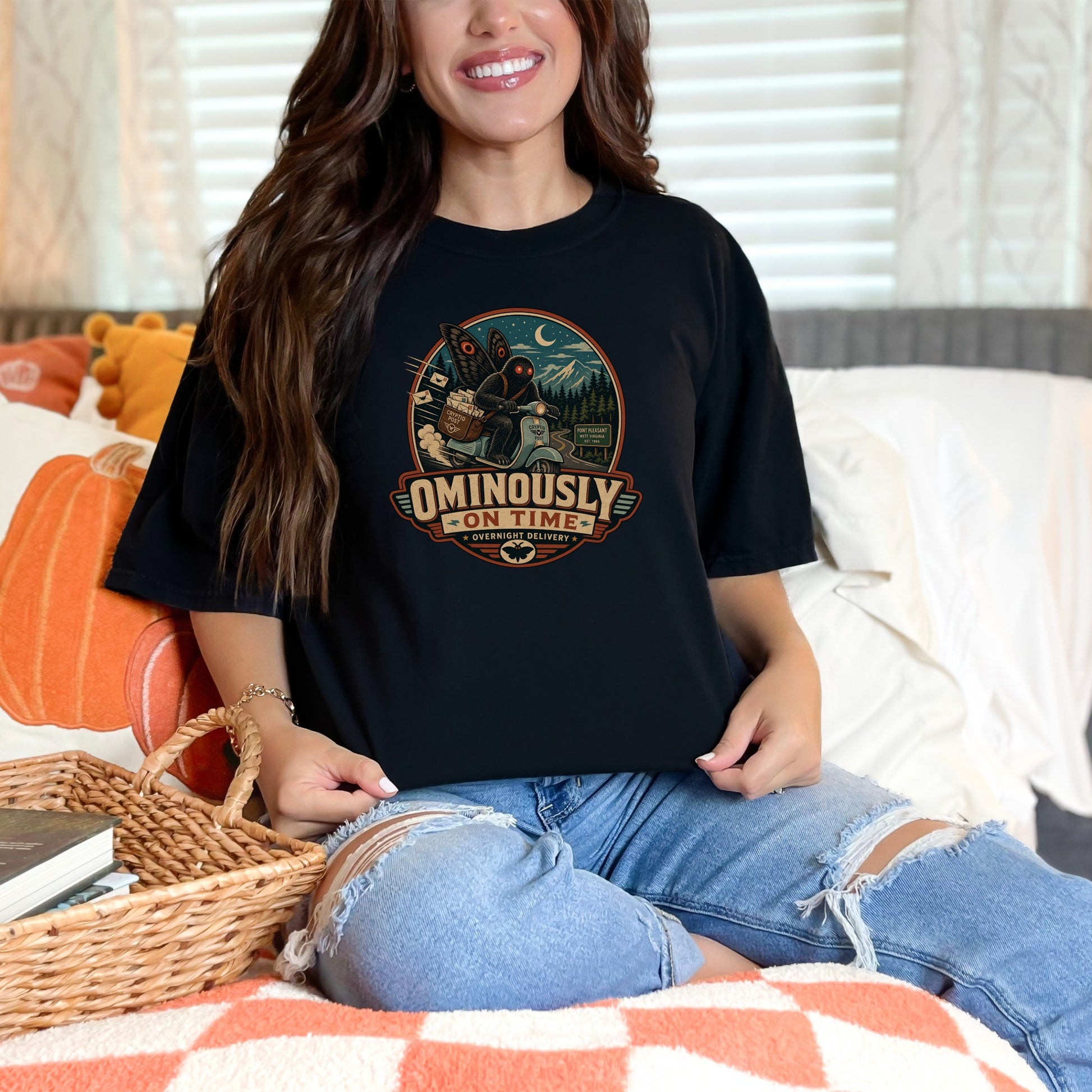 Black t-shirt with "Ominously On Time Overnight Delivery" graphic featuring a mothman.