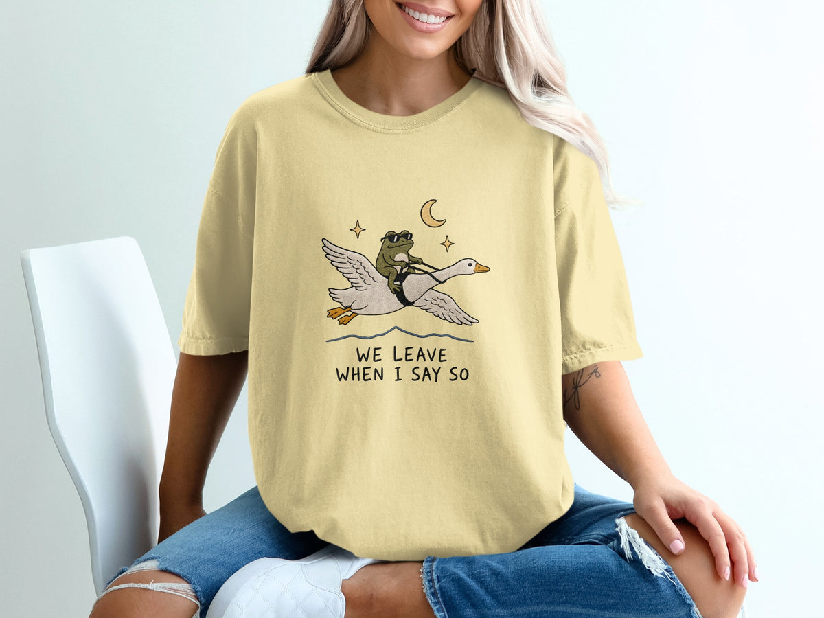 Yellow t-shirt with graphic of frog riding goose, "We Leave When I Say So."