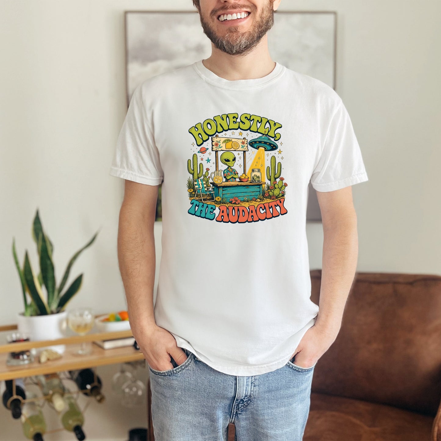 White t-shirt with retro graphic of alien at a lemonade stand, saying "Honestly, The Audacity."