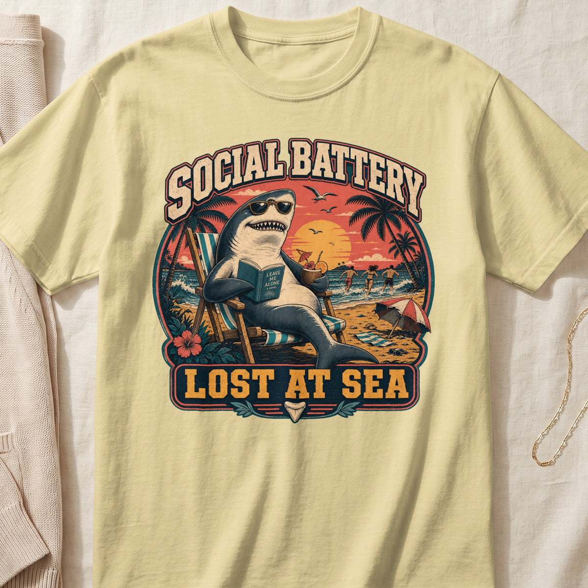 Shark reading "Leave Me Alone" at the beach with text "SOCIAL BATTERY LOST AT SEA".