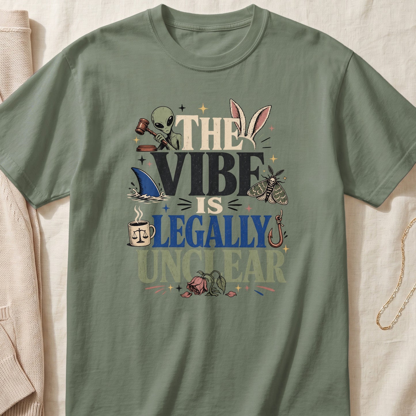Green t-shirt with "The Vibe Is Legally Unclear" text and whimsical graphics.