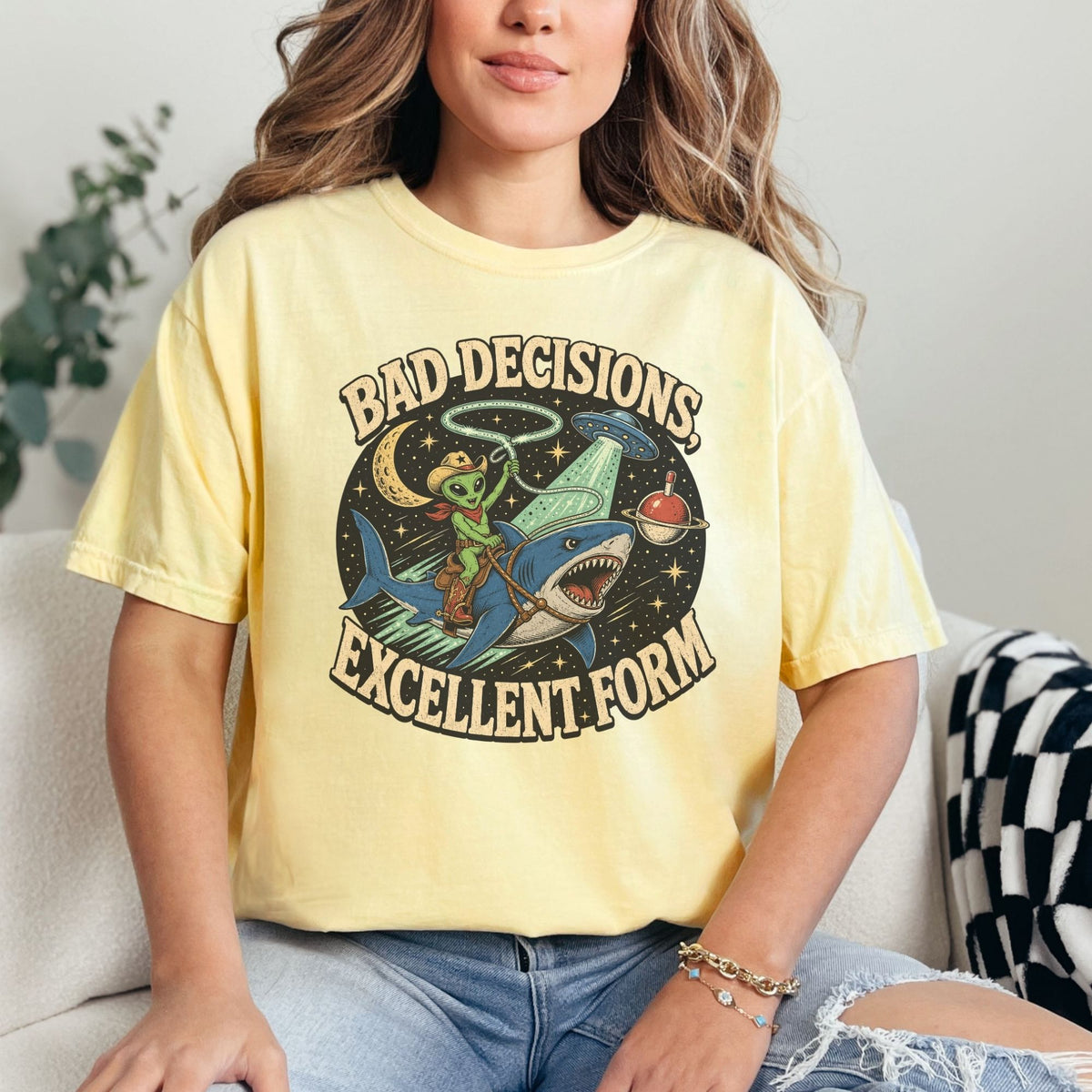 Graphic tee with alien riding shark, UFO, moon, and text "BAD DECISIONS, EXCELLENT FORM".