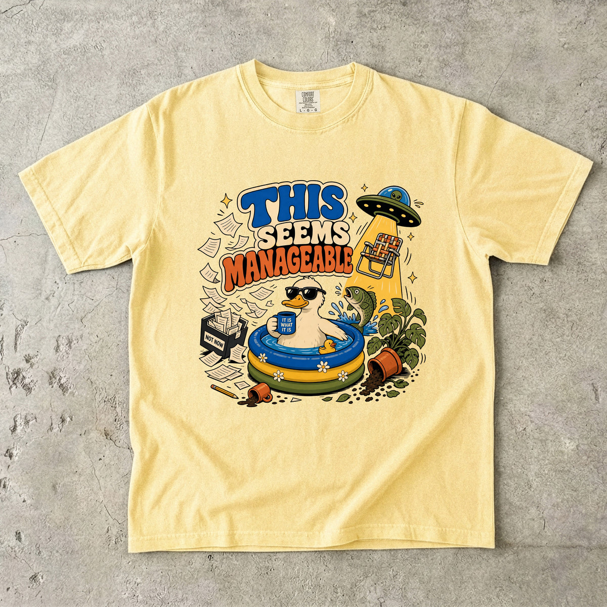 Yellow t-shirt with "THIS SEEMS MANAGEABLE" text and cartoon duck in pool.