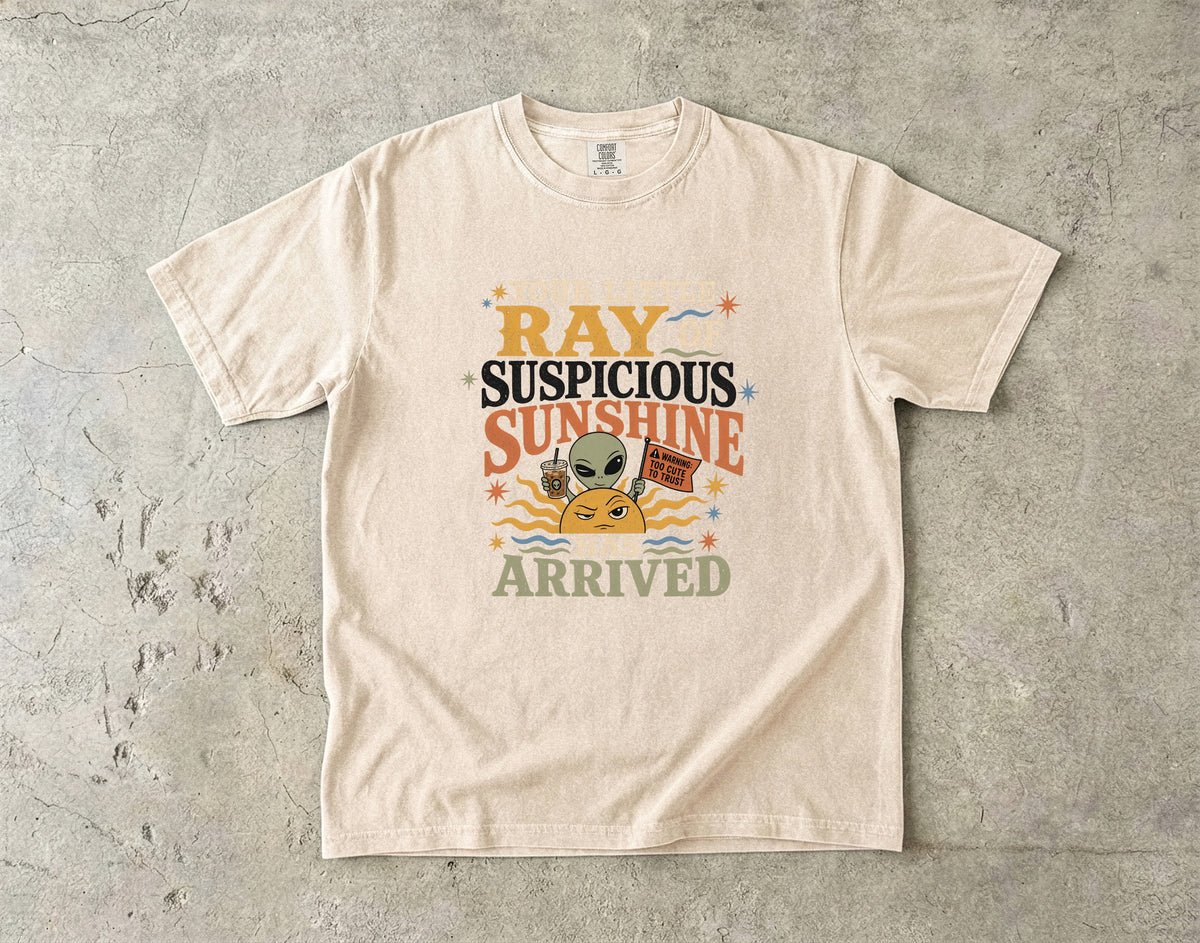 Light tan t-shirt with "RAY SUSPICIOUS SUNSHINE ARRIVED" text and alien graphic.