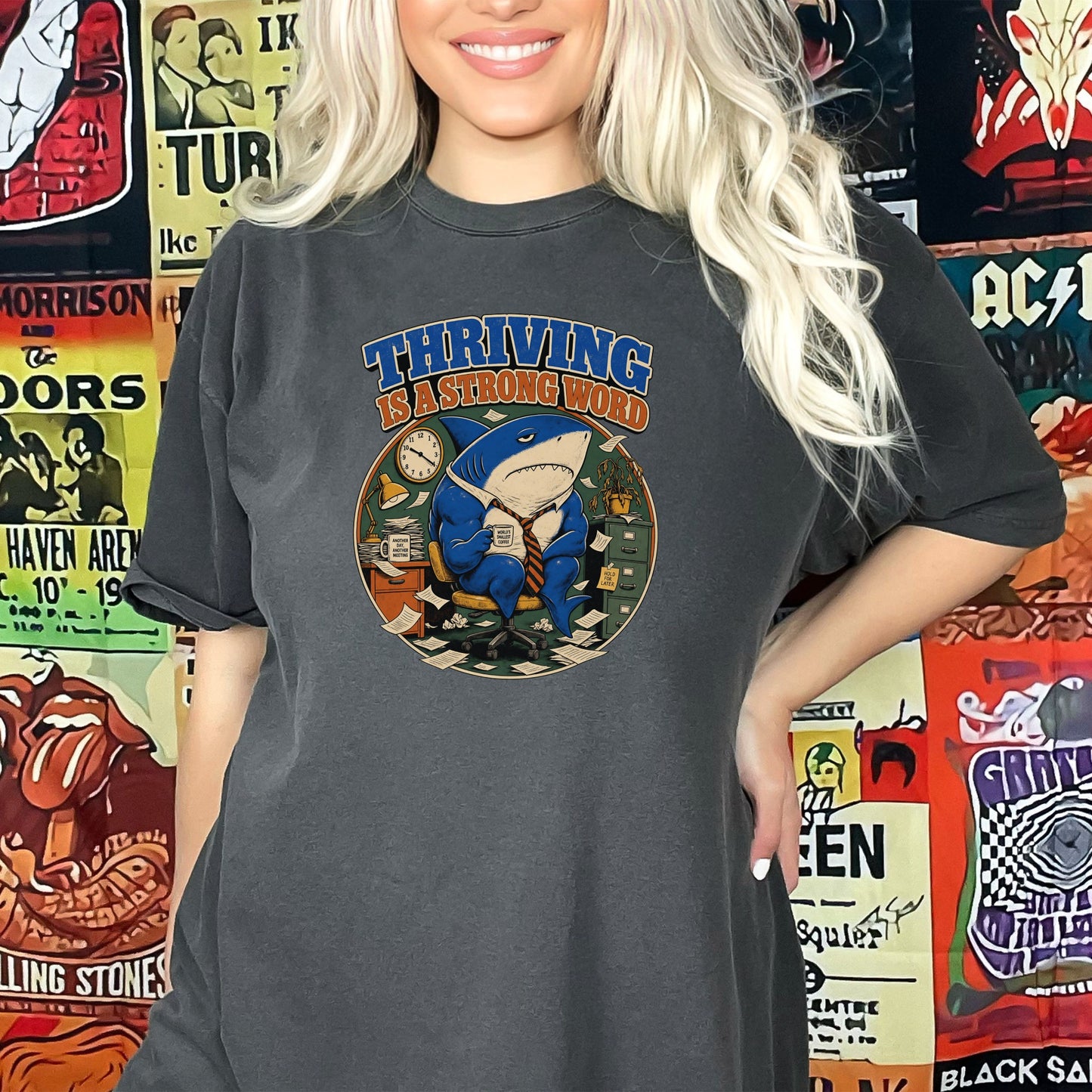 T-shirt graphic of a shark in a suit at a desk with text "THRIVING IS A STRONG WORD".