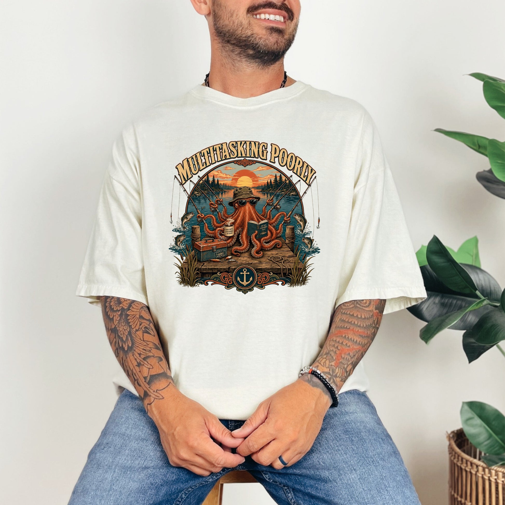 T-shirt graphic with octopus fishing, "Multitasking Poorly" text, and sunset scene.