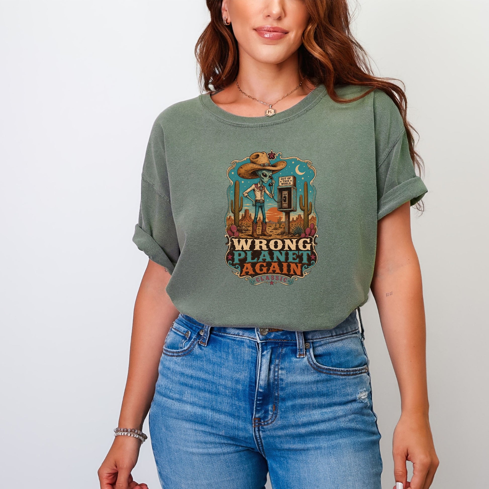 Green t-shirt with desert graphic and text "WRONG PLANET AGAIN CLASSIC".
