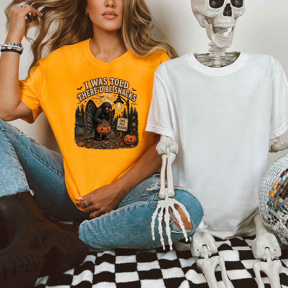 Orange t-shirt with "I Was Told There'd Be Snacks" Mothman graphic.