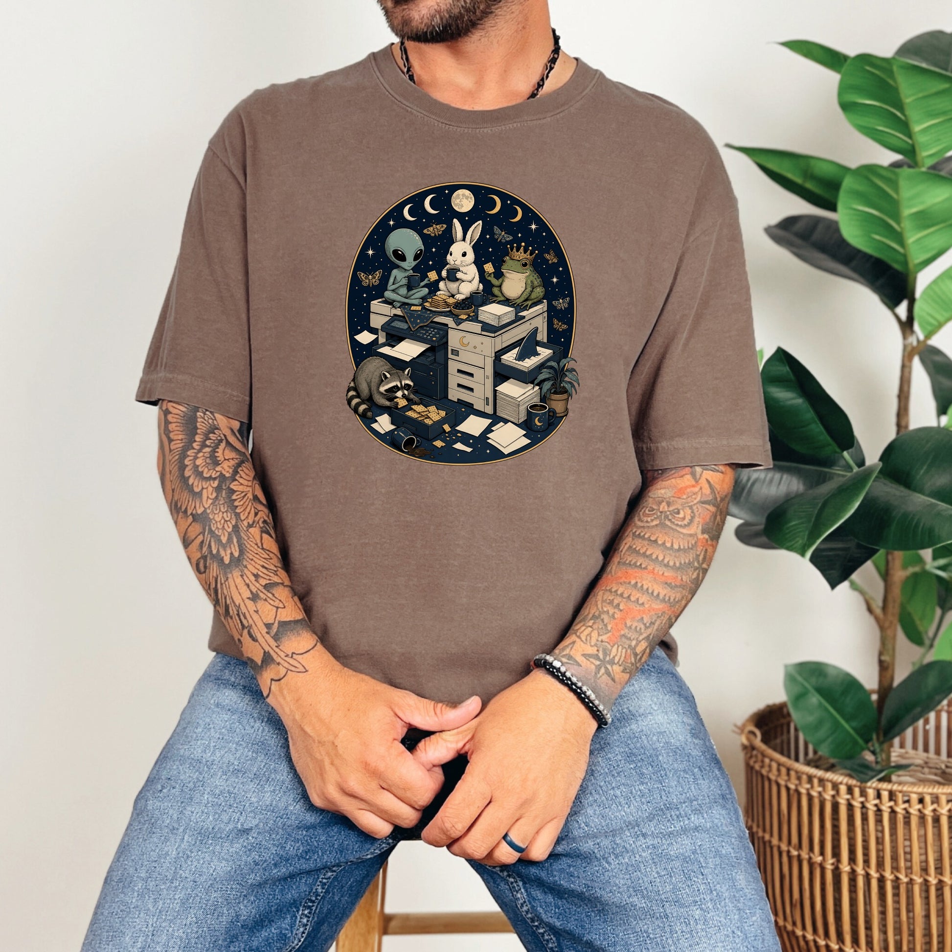 A man wearing a brown t-shirt featuring a surreal office animal graphic.