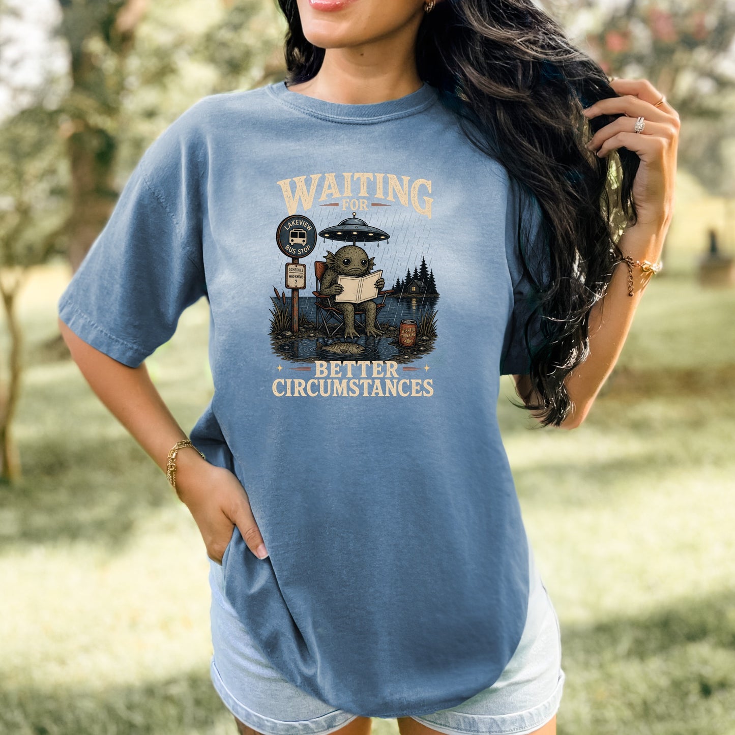 Graphic of a creature under a UFO at a bus stop with text "Waiting for Better Circumstances."