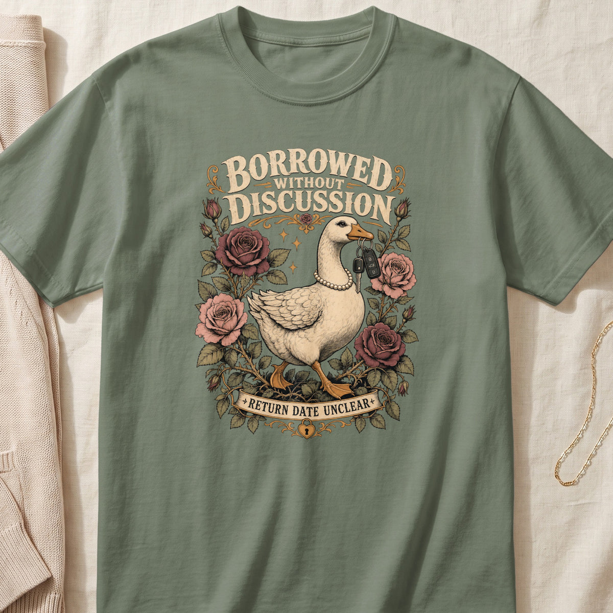 Green t-shirt with goose, keys, roses, and text "Borrowed Without Discussion Return Date Unclear."