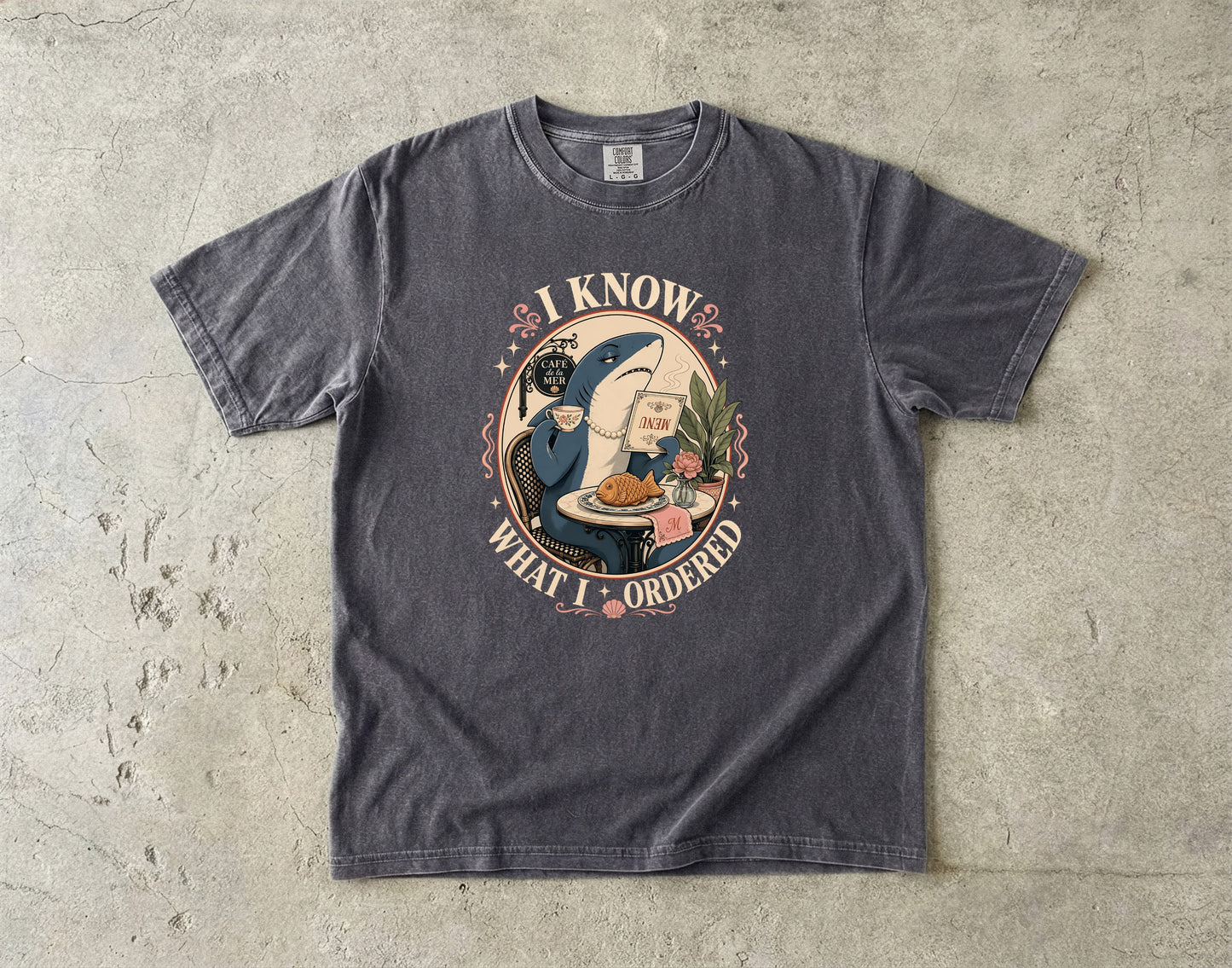 Dark grey t-shirt with graphic of a shark in a cafe, saying "I Know What I Ordered".