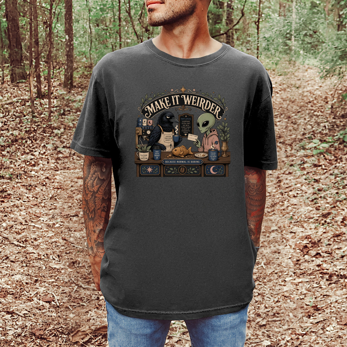 T-shirt with "Make It Weirder" text, a crow, an alien, and coffee shop elements.