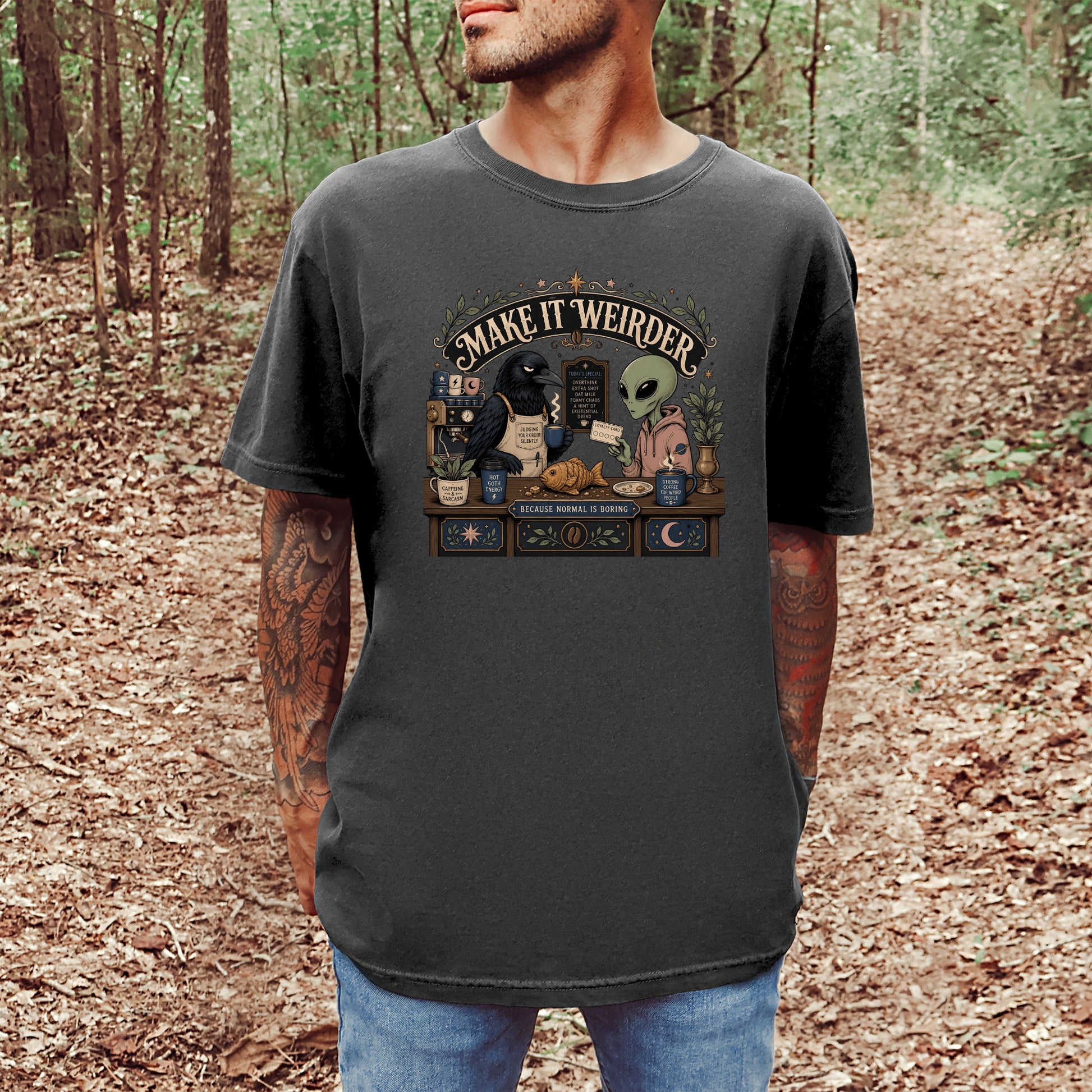 T-shirt with "Make It Weirder" text, a crow, an alien, and coffee shop elements.