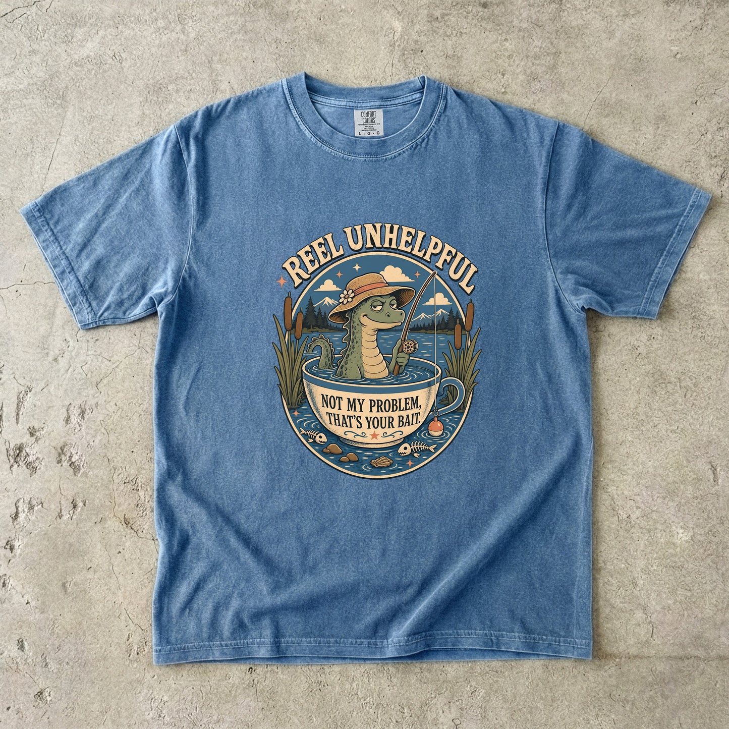 T-shirt with graphic of alligator in a teacup fishing, text "REEL UNHELPFUL" and "NOT MY PROBLEM, THAT'S YOUR BAIT."
