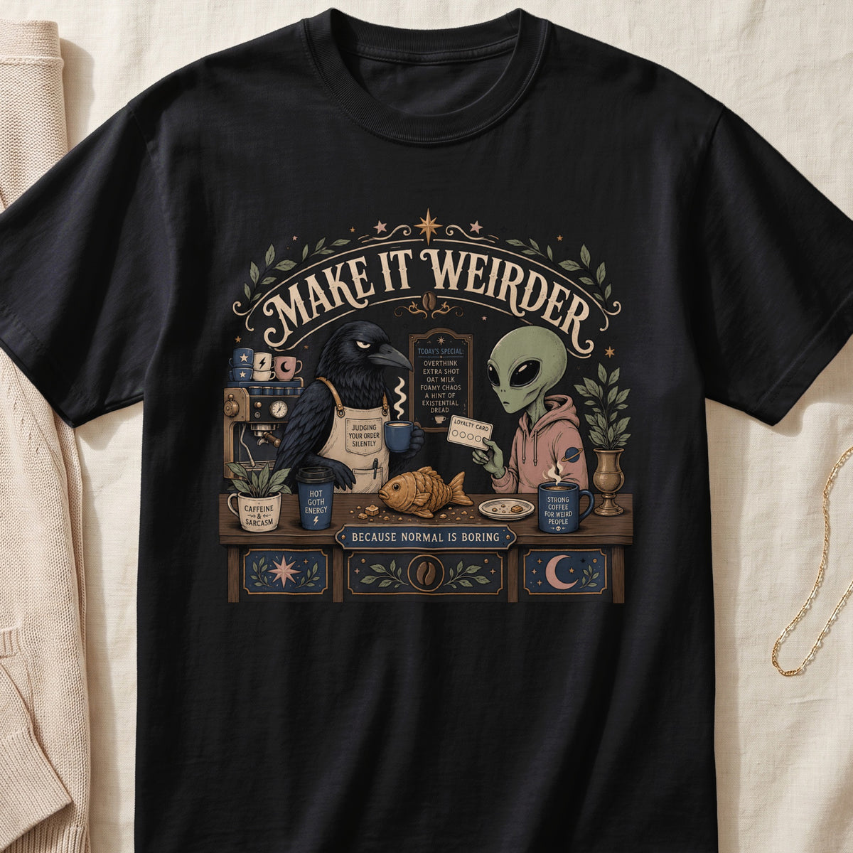 T-shirt with a raven barista and alien customer at a coffee bar, "Make It Weirder" text.