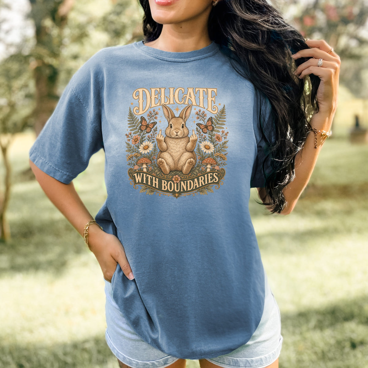 Blue t-shirt with a graphic of a rabbit giving the middle finger and text "DELICATE WITH BOUNDARIES".