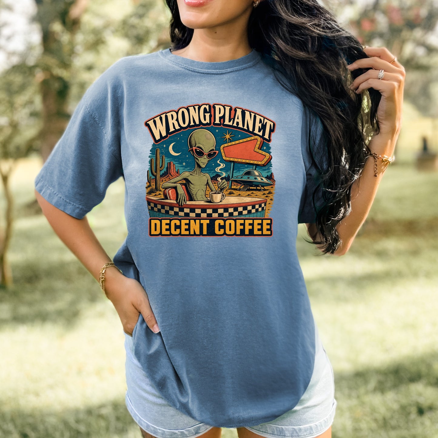 Alien in sunglasses at a cafe with text "WRONG PLANET DECENT COFFEE".