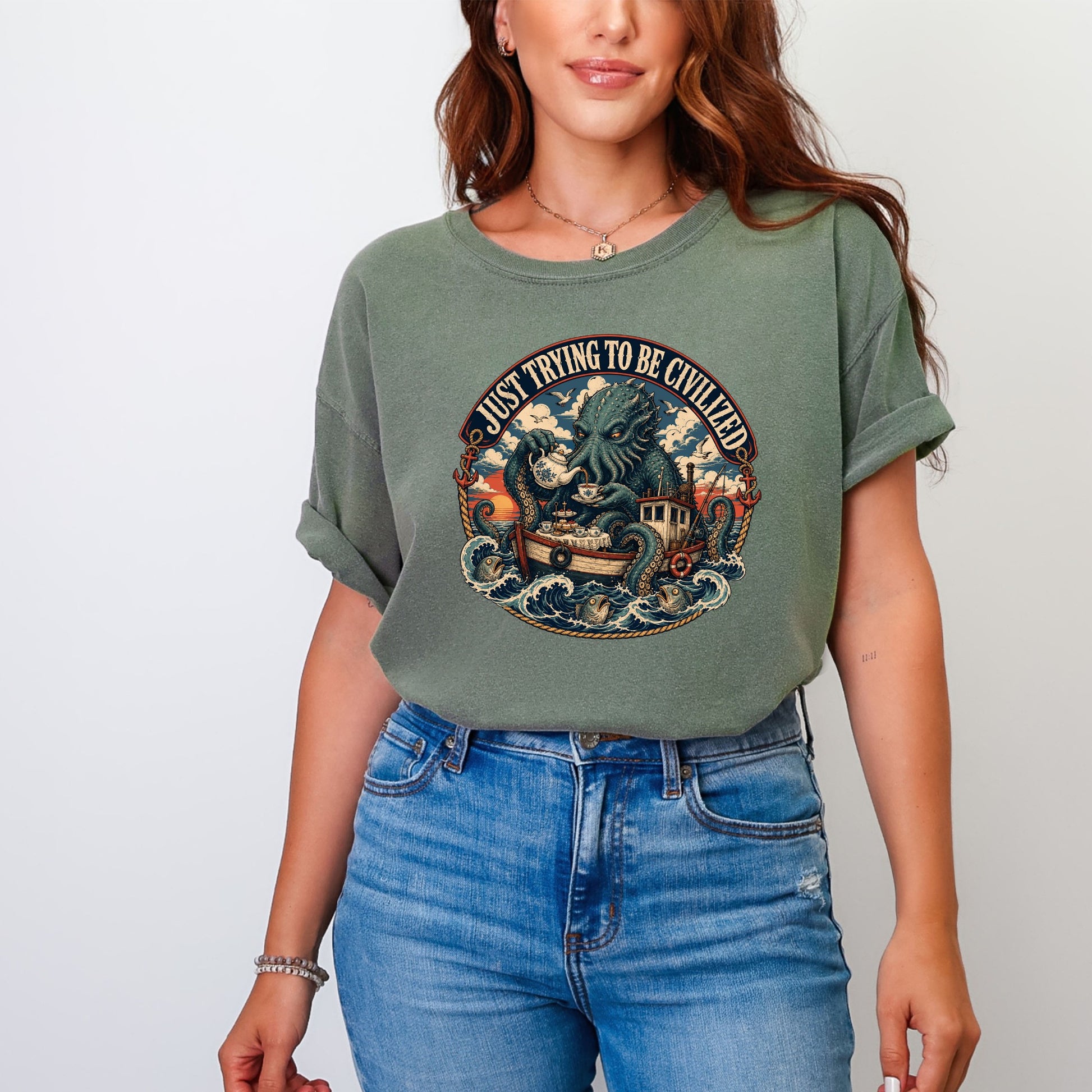 Green t-shirt with a circular graphic of a kraken serving tea on a boat.