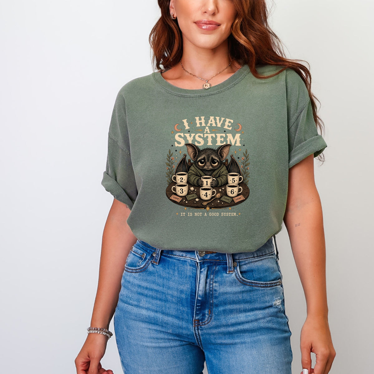 Green t-shirt with "I HAVE A SYSTEM" and a bat holding coffee cups.