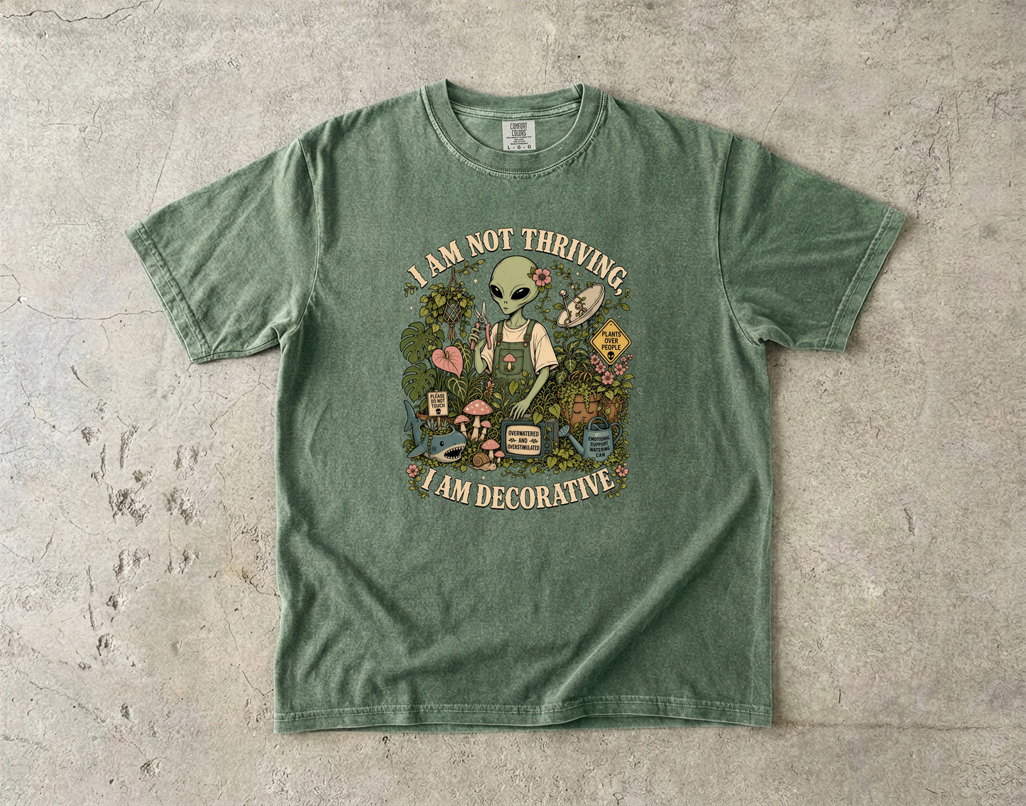 Green t-shirt with alien gardener and text "I AM NOT THRIVING, I AM DECORATIVE".