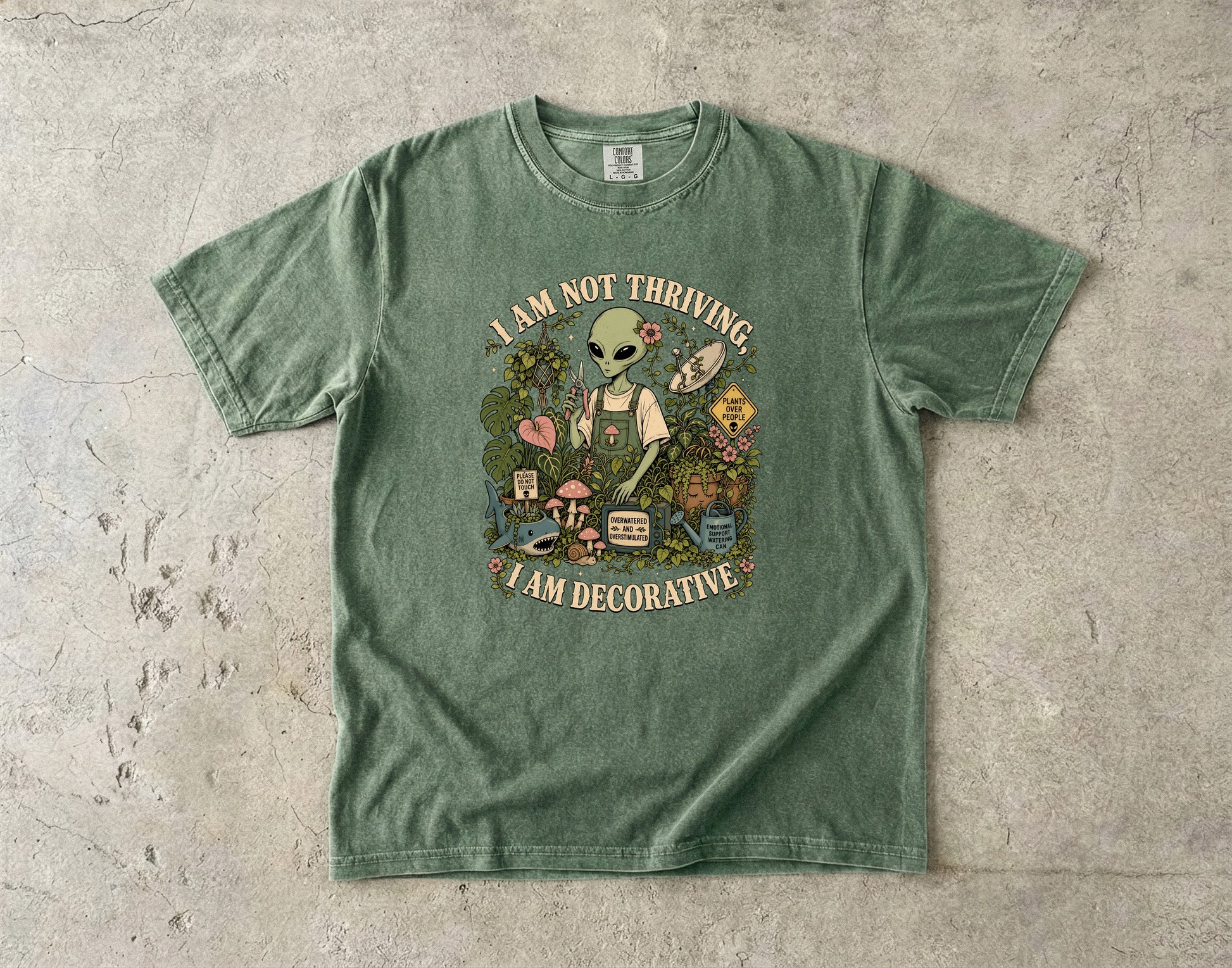 Green t-shirt with alien gardener and text "I AM NOT THRIVING, I AM DECORATIVE".