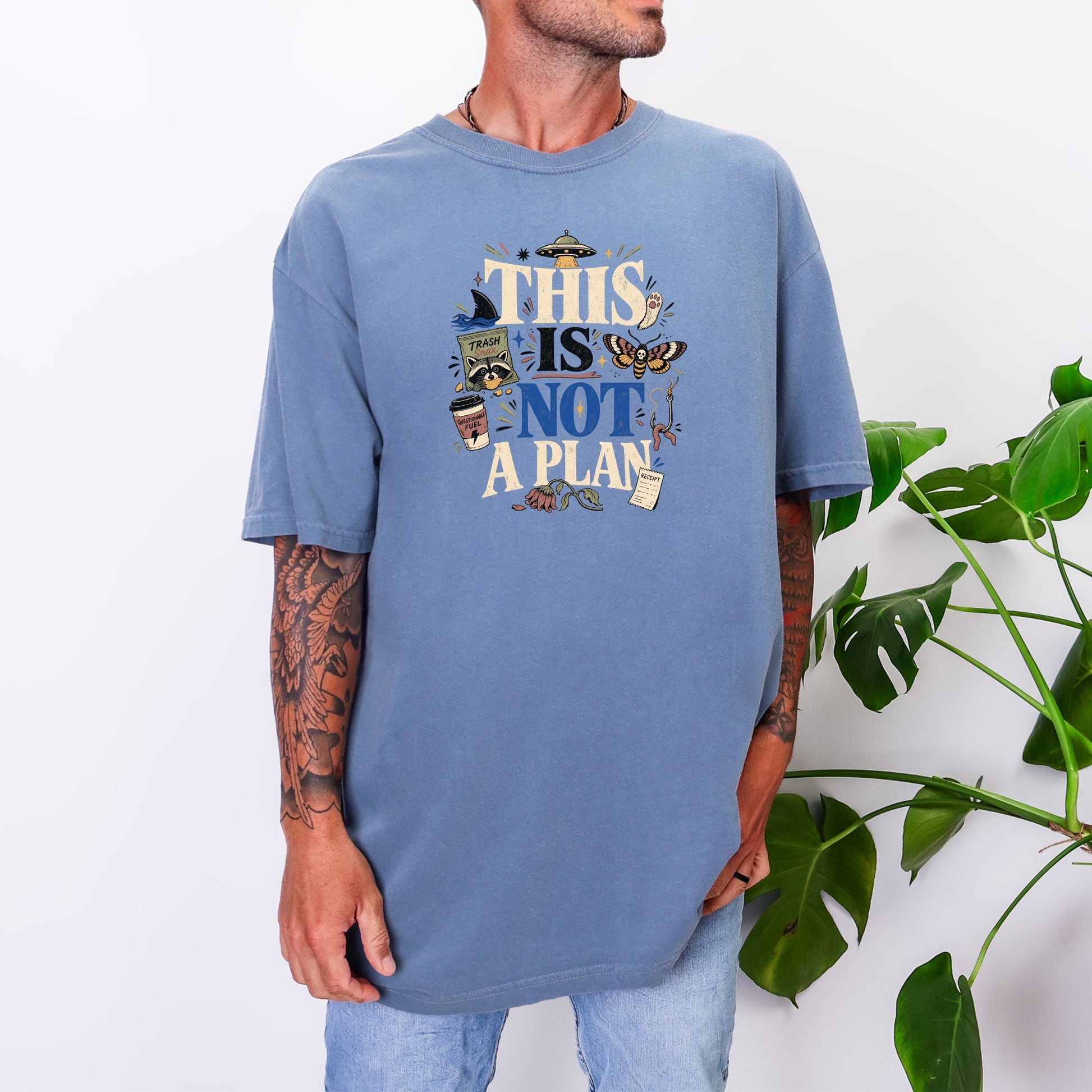 Blue t-shirt with "THIS IS NOT A PLAN" text and quirky illustrations.