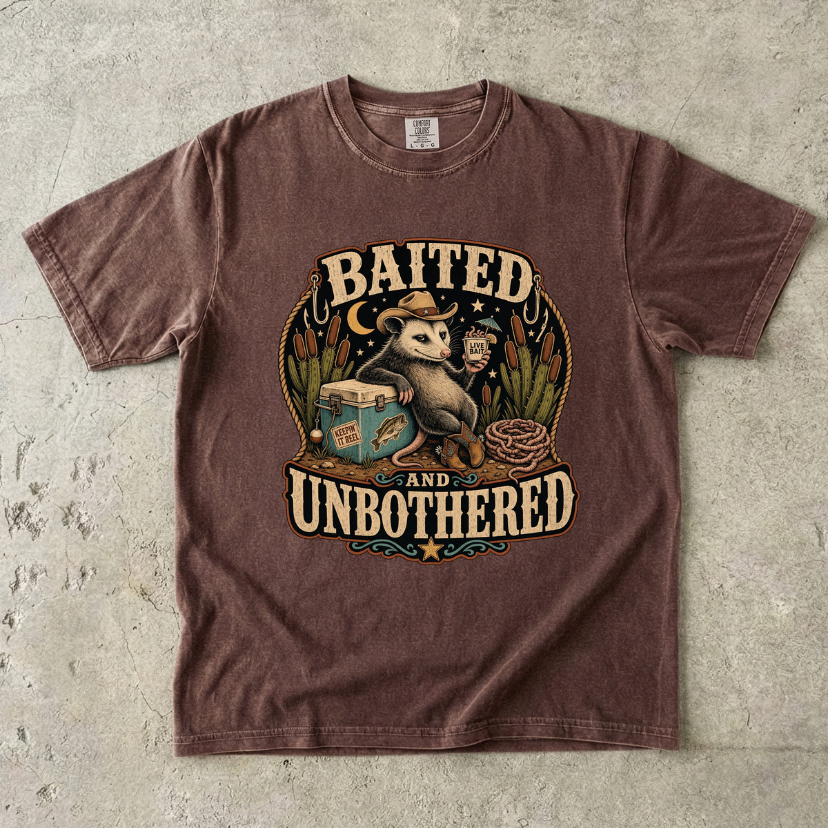 Brown t-shirt with graphic text "BAITED AND UNBOTHERED" and an opossum.