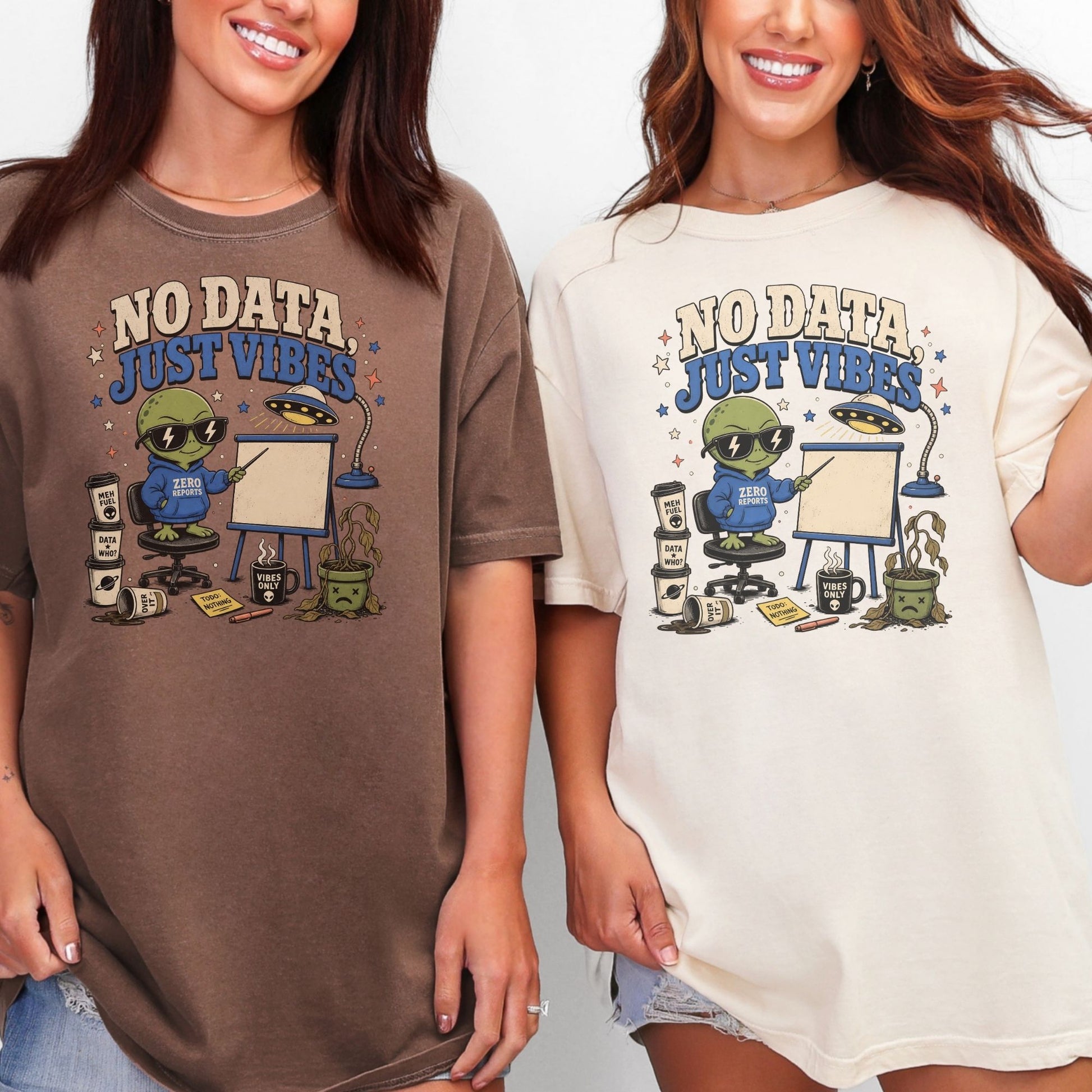 Two women model graphic t-shirts with an alien presenting "No Data, Just Vibes" on a whiteboard.