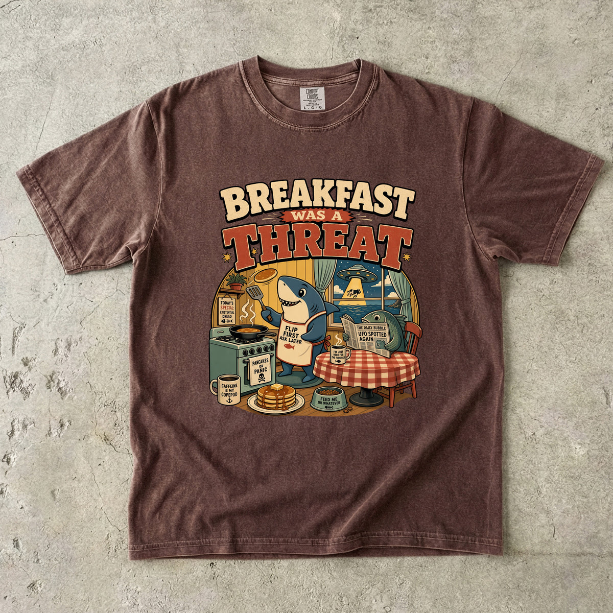 T-shirt with "Breakfast Was A Threat" graphic featuring a shark cooking pancakes and a UFO abduction.