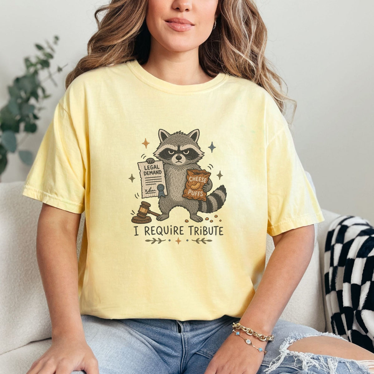Raccoon holding cheese puffs and legal demand document, with gavel and text "I REQUIRE TRIBUTE."