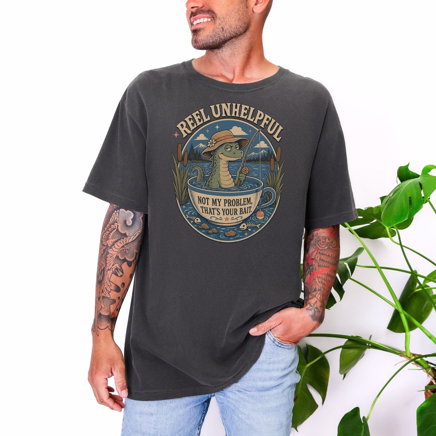 T-shirt with illustration of alligator fishing in a teacup, text "Reel Unhelpful."