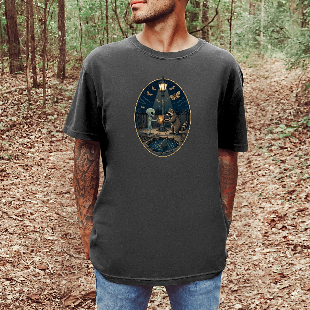 T-shirt with alien and raccoon sharing a glowing object by a street lamp.