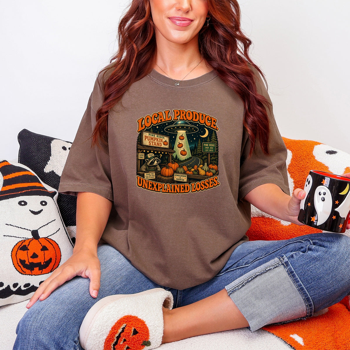 Graphic t-shirt with "Local Produce Unexplained Losses" text and UFO theme.