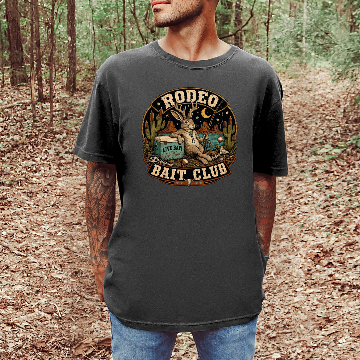 T-shirt with a circular graphic of a rabbit fishing, surrounded by cacti and text "RODEO BAIT CLUB".