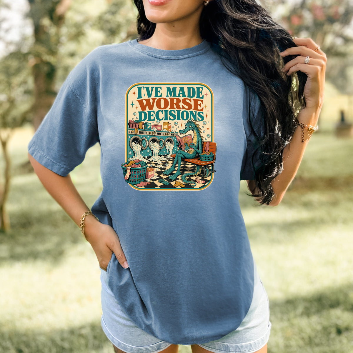 T-shirt graphic of a dragon reading a book amidst laundry and washing machines.