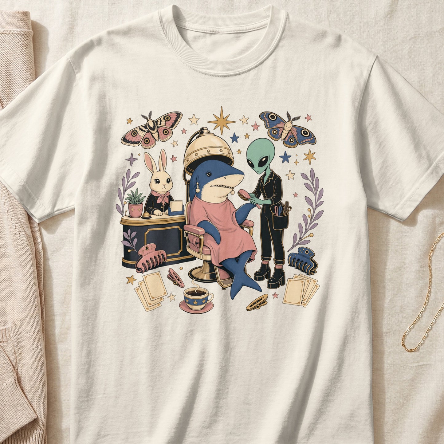 A cream t-shirt featuring a surreal cartoon illustration of an alien styling a shark's hair.